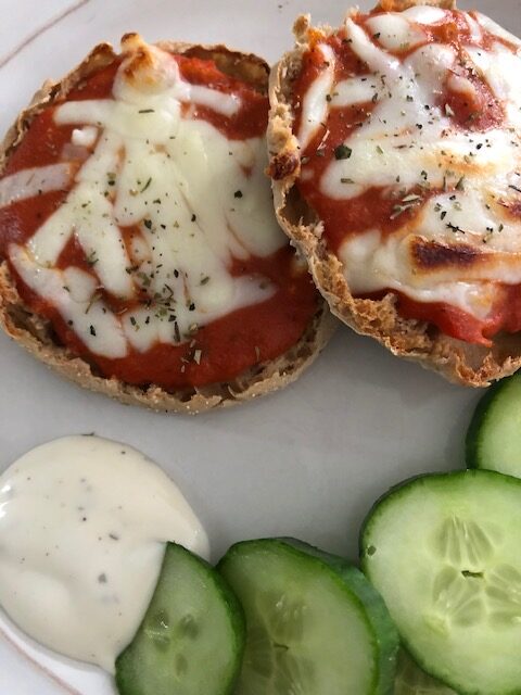quick healthy lunch of muffin pizzas and cucumbers.